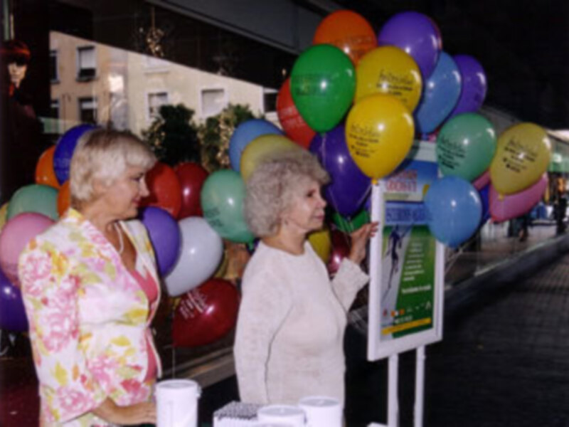 La Sra. Duquesa de Alba Presidenta de Honor y Águeda Alonso, Presidenta de "ASEM" en la mesa que presiden en la Plz. del Duque, soportales de El Corte Inglés.