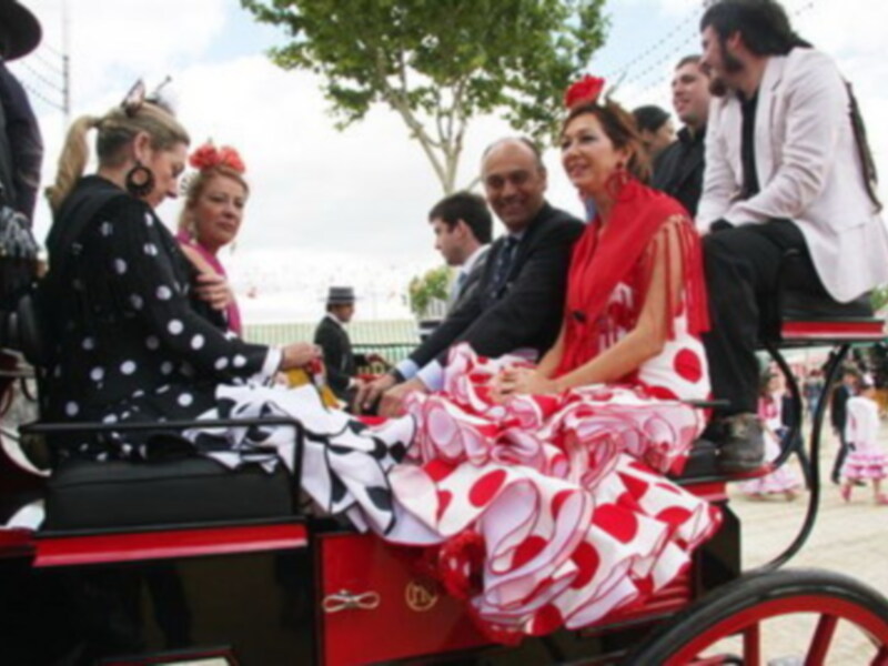 Fiesta tradicional con mujeres vestidas con trajes típicos en un carruaje, celebrando el espíritu festivo.