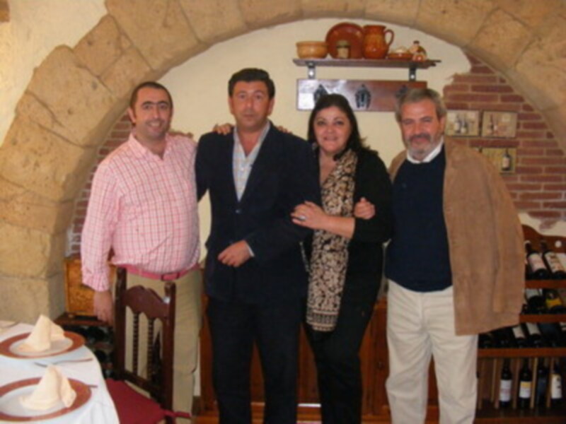 Grupo de personas posando juntos en un ambiente acogedor con decoración de ladrillo y cerámica.