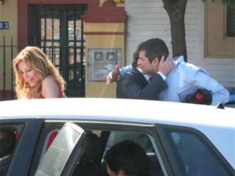 Un hombre y una mujer saliendo de un coche en una calle urbana.